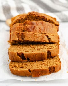 Slices of Pumpkin Bread on Parchment with Stripe Towel in Background