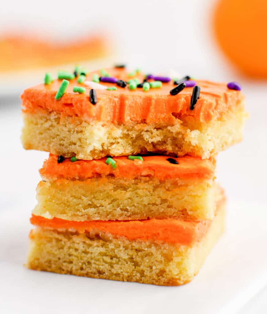 Stacked Sugar Cookie Bars with Orange Frosting and Halloween Sprinkles