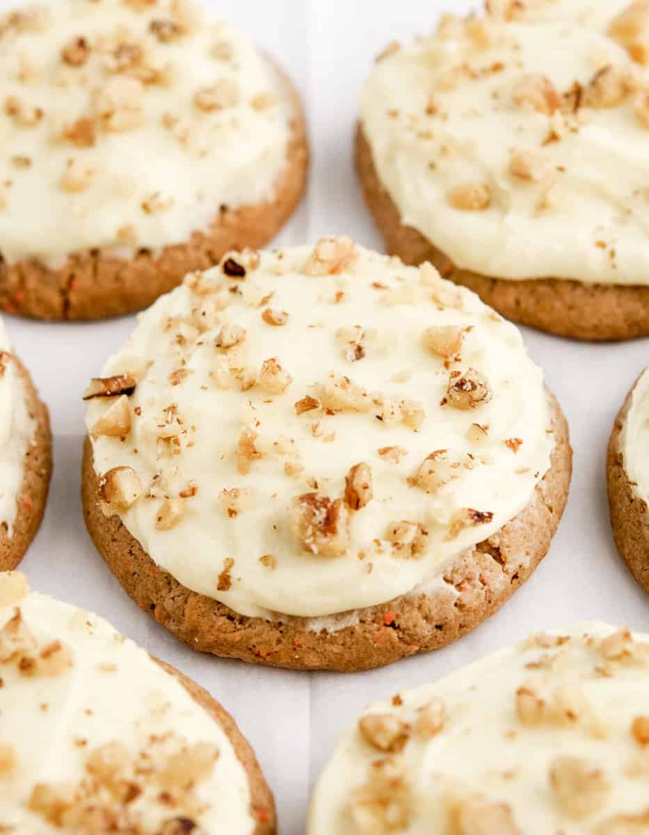 Carrot Cake Cookies with Cream Cheese Frosting and Chopped Nuts on Parchment Paper