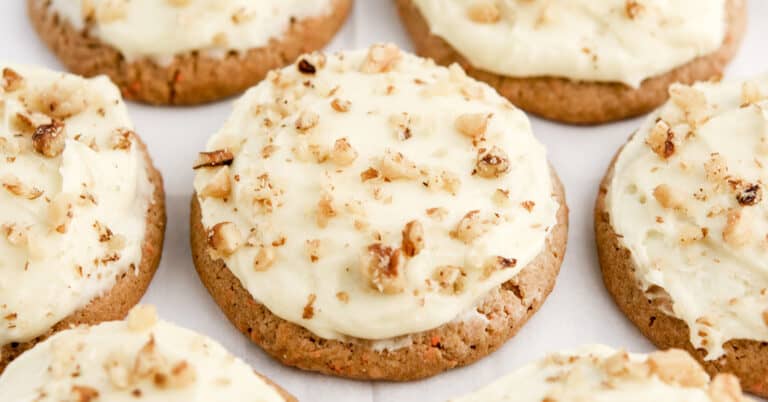 Carrot Cake Cookies with Cream Cheese Frosting and Chopped Nuts on Parchment Paper