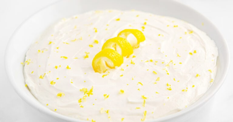 Close up of Lemon Cheesecake Dip with Lemon Twist and Zest in White Bowl