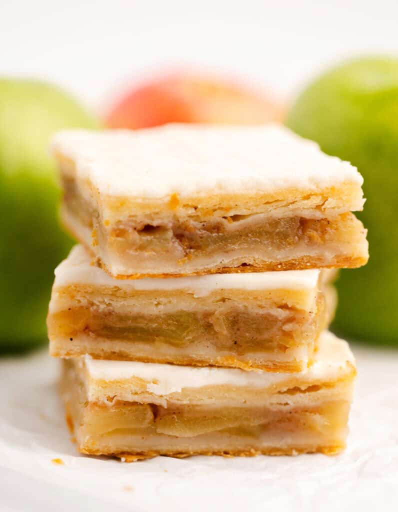 Apple Pie Bars Stacked with Green Apples Behind