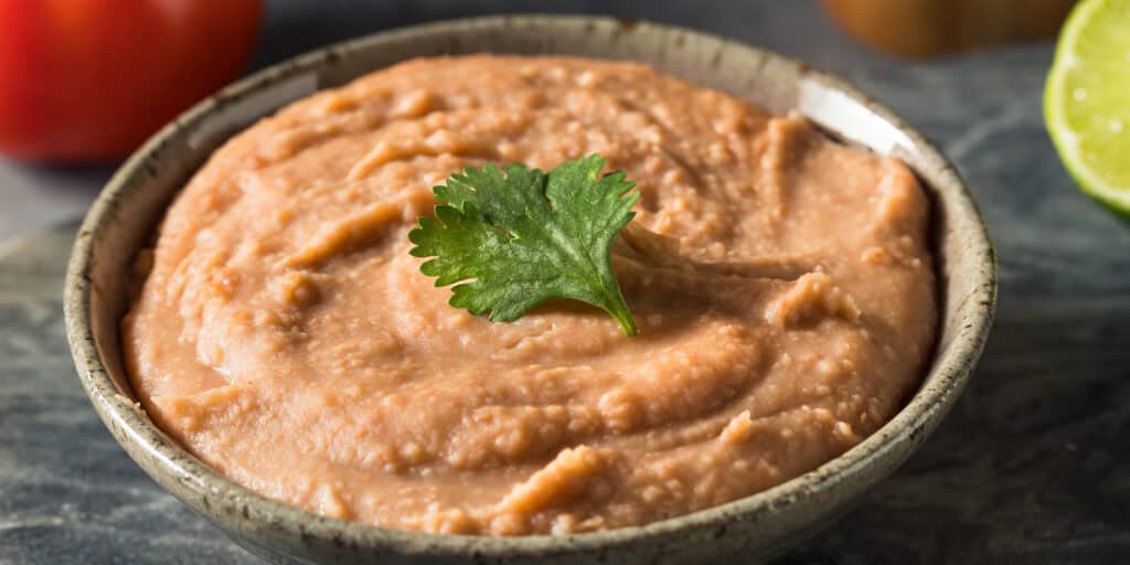 Refried Beans in Bowl with Fresh Herb Garnish
