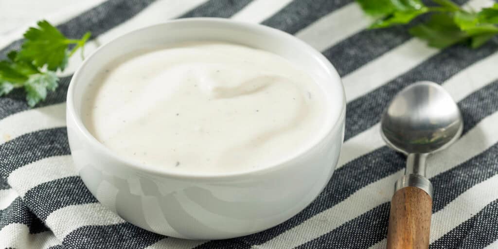 Bowl of White Sauce on Black and White Striped Towel