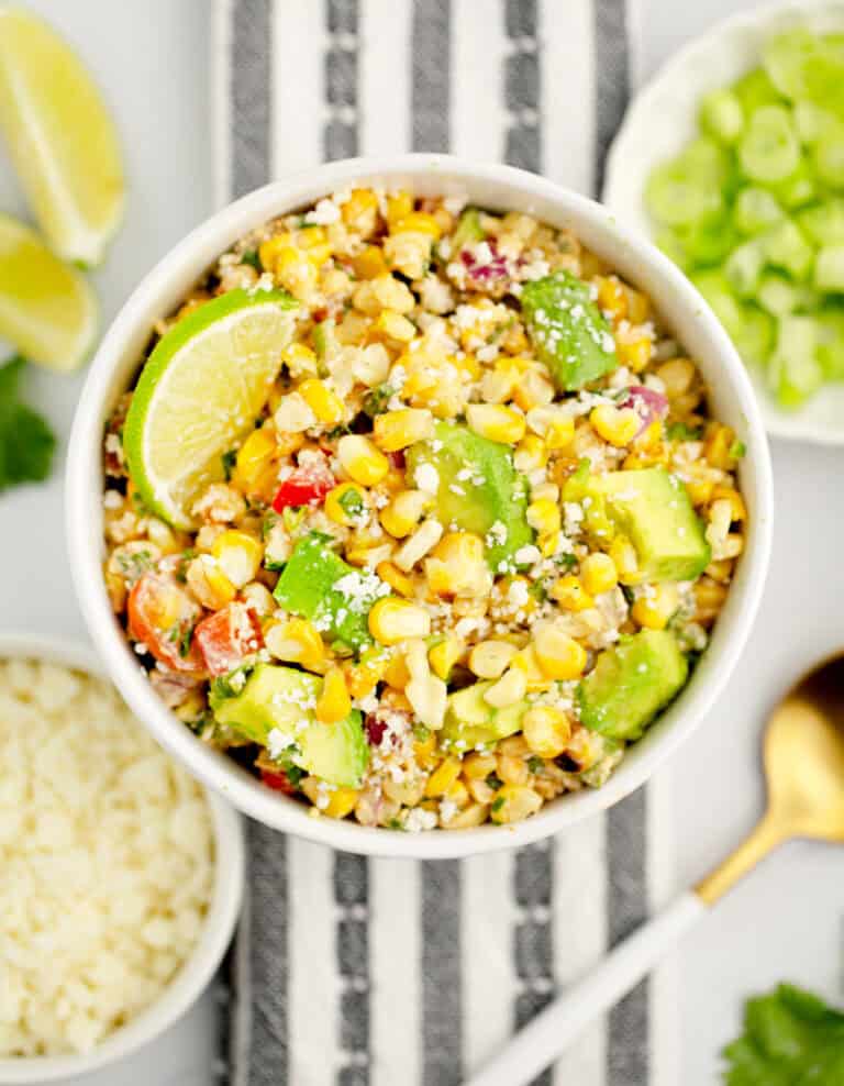 Mexican Street Corn Salad in White Bowl with Lime and Avocado