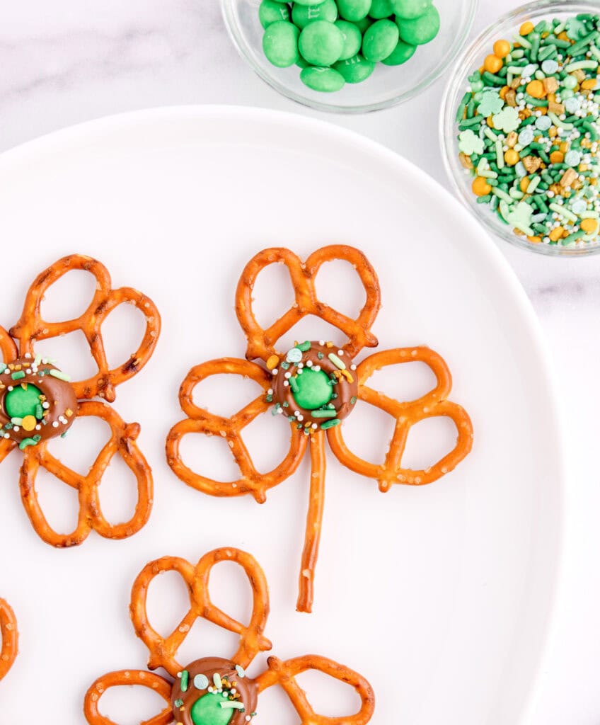 Shamrock Pretzel Pops on Platter with Bowls of M&Ms and Sprinkles
