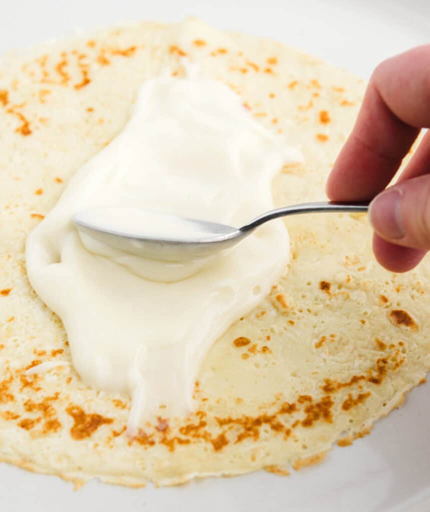 Spreading Cream Cheese on Crepes with Spoon