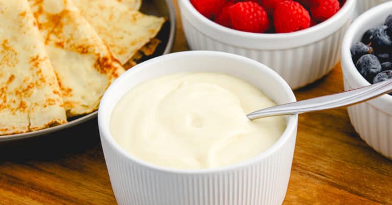Sweet Cream Cheese Crepe Filling in Bowl with Berries and Crepes in the Background